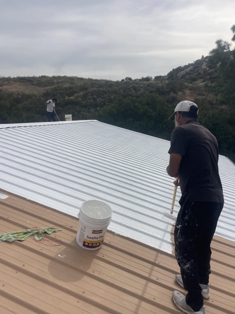 Applying reflective roof coating to a metal roof in San Diego County by Luna Roofing